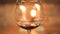 Pouring red wine in empty wineglass at evening dinner with candles background. Red wine pouring to glass from bottle