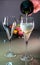Pouring of sparkling white wine champagne or cava with bubbles and sweet dessert colorful macarons biscuits on background