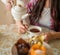 Pouring tea from porcelain teapot to the cup.