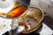 Pouring used cooking oil from frying pan into colander