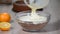 Pouring vanilla white cream into bowl with cake crumbles . Pastry work.