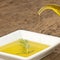 Pouring virgin olive oil in a plate