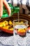 Pouring water from green bottle into a glass. Fried potatoes dish in the background