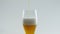 Pouring wheat beer glass at white background close up. Alcohol beverage flowing.