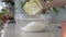 Pouring wheat flour into a bowl - preparation for baking Christmas cookies