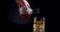 Pouring whiskey in glass. Alcohol concept. Dark background. White man pour tasty drink into the whiskey glass Advert