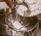 Pouring white flour powder into a sieve.