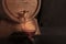 Pouring wine into a glass from a barrel, a closeup on a dark background