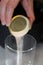 Pouring yeast grains to make bread into a glass