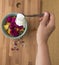 Pouring yogurt in a bowl of fruits