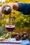 Pouring yound red beaujolais wine in glass during celebration of end of harvest and first sale release on third Thursday of