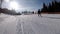 POV Beginner Girl on Skis and Amateur Skiers Slide Down on Ski Slope at Ski Resort Against the Sun
