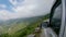 POV: Driving along the edge of scary bumpy road overlooking a village in Nepal.