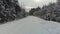 POV: driving on a snowy winter road in a dense dense forest