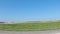 POV driving street pan massive construction area with dozens of cranes clear blue sky