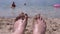 POV Female Wet Feet in Sand Lying on a Sandy Beach in Sun Glare near the Sea