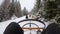 POV first person view of sled dogs pulling team with person on snow in winter mountain landscape