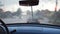 POV from the front seat to windshield of old retro car during bad weather. Wipers removing raindrops from the window of