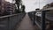 Pov hyperlapse walking in railway bridge with city life people walking and cross the bridge with city skyline