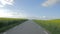 POV idyllic drive along countryside. Farm fields, blue sky with clouds