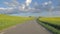 POV idyllic drive along countryside. Farm fields, blue sky with clouds