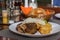 POV Lamb cauldron kabob with fresh vegetables and fried potato on white plate