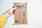 POV male hand holding unopened Amazon prime cardboard envelope with its smiling