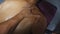 POV male hands of professional masseur massaging shoulder of athlete lying on massage table in parlor. Arms of massagist