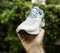 POV man hand demonstrating against green background professional running shoe