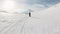 Pov man with snowboard walking on mountain. Group expedition in front on skies moving on pure white snow. Magnificent