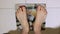 POV of an overweight man`s bare feet weighing himself on a bathroom scale