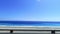 POV-Passenger side window driving scene. blue ocean against  blue sky