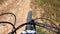 POV, Rrding mountain bike in a small singletrack dusty trail in the mountain.