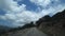 POV shot. Car climbing to the mountains along a steep narrow road along the sea, view from the car