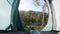 POV shot, traveler resting in a tent with a view to the river in the forest.