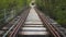 POV shot walking along a railway line. Old abandoned single track on rural countryside landscape.