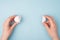 Pov top above overhead closeup photo of hands holding separating two halves of cracked egg isolated over blue background