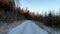 POV video driving a car on a snowy forest road in winter at sunset.