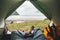 POV view of hipster tourist inside tent on front of mountains and sea