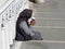 Poverty and begging, woman on stairs