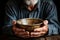 Poverty personified old mans hands, empty bowl, wood backdrop symbolizing destitution