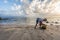 Poverty village woman picks up seaweed along the beach