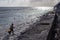 Poverty village woman picks up seaweed along the beach