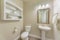 Powder room interior with beige walls and framed shelves with ornamental displays