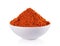 Powdered dried red pepper in white bowl on white background