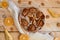 A powdered pear pie decorated with white cloth, fresh sliced pears, dried oranges, walnuts, anise stars, spoon on the wooden table