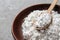 Powdered white sugar with stevia pills in bowl on grey table, closeup