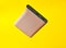 Power bank pale pink color on a yellow background. External battery for gadgets. Levitation of objects