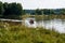 Power boat with people floating on the pond in the countryside in summer.