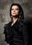 The power and confidence. Portrait of young beautiful woman with dark hair. Dress and earring with feathers